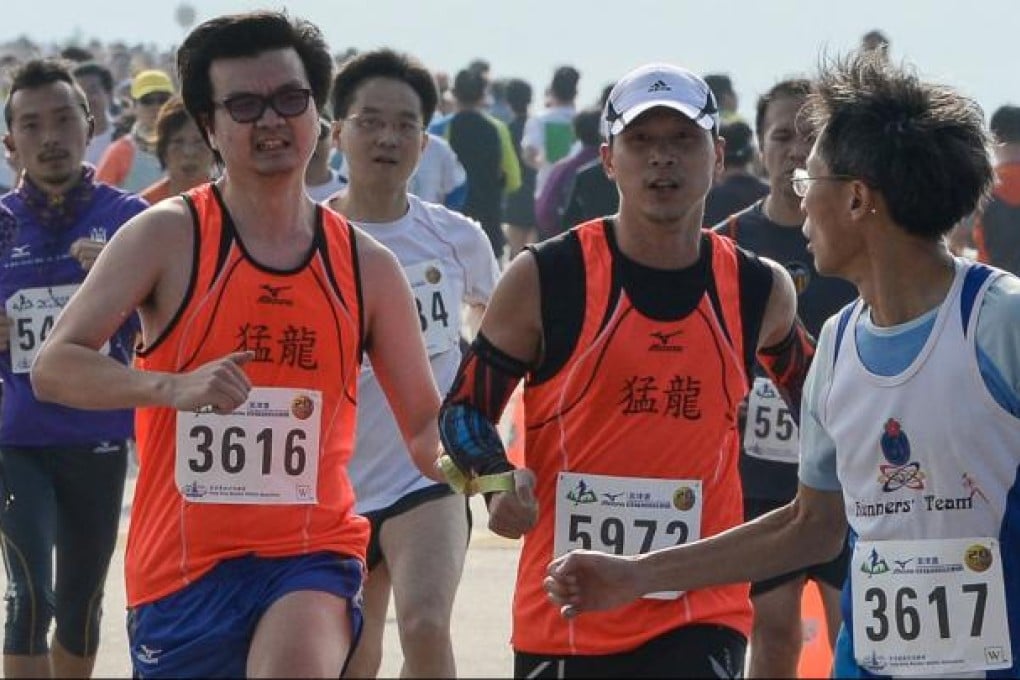 Blind runner Galant Ng (3616) and deaf guide Michael Ng (5972) finish the 20th Mizuno Hong Kong Half Marathon Championships. Photo: Richard Castka/Sportpix International