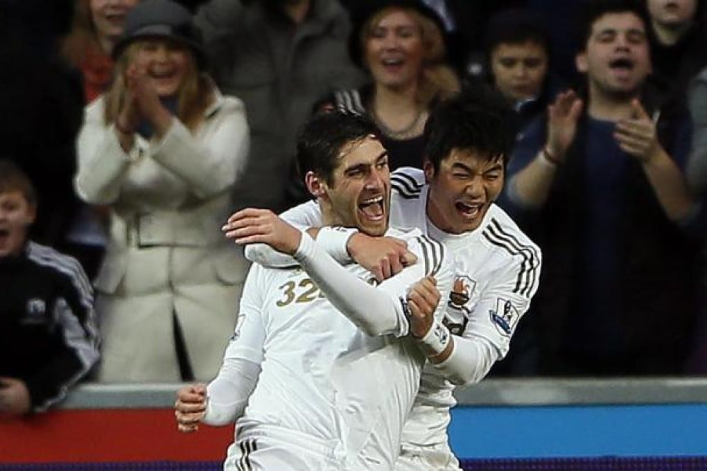 Swansea City's Danny Graham celebrates with teammate Ki Sung-yueng after scoring the equaliser against Arsenal. Photo: Reuters