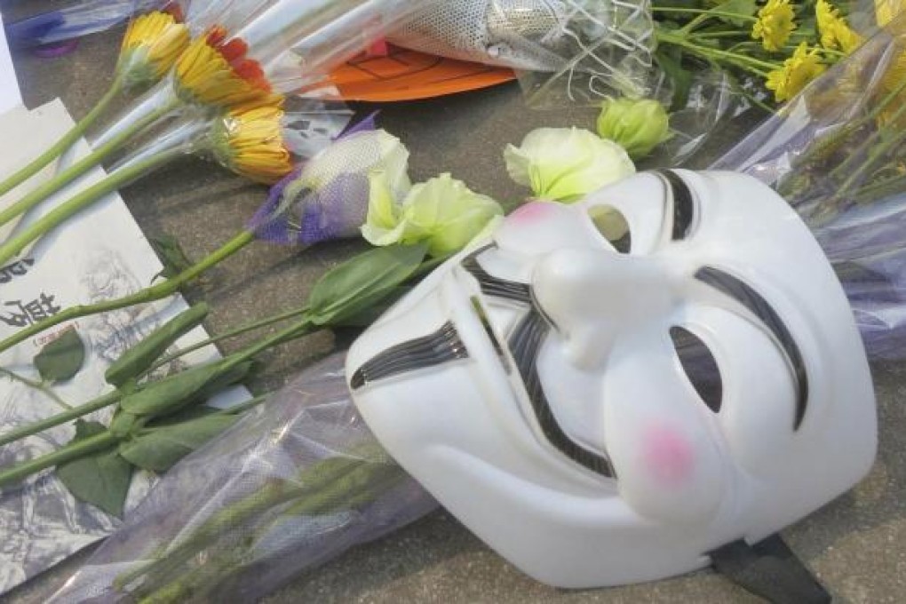 A Guy Fawkes mask among protest symbols. Photo: Reuters