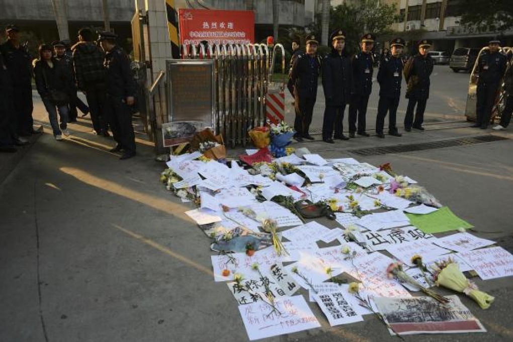 Protest banners and flowers are laid outside the Southern Weekly office in Guangzhou. Photo: AP