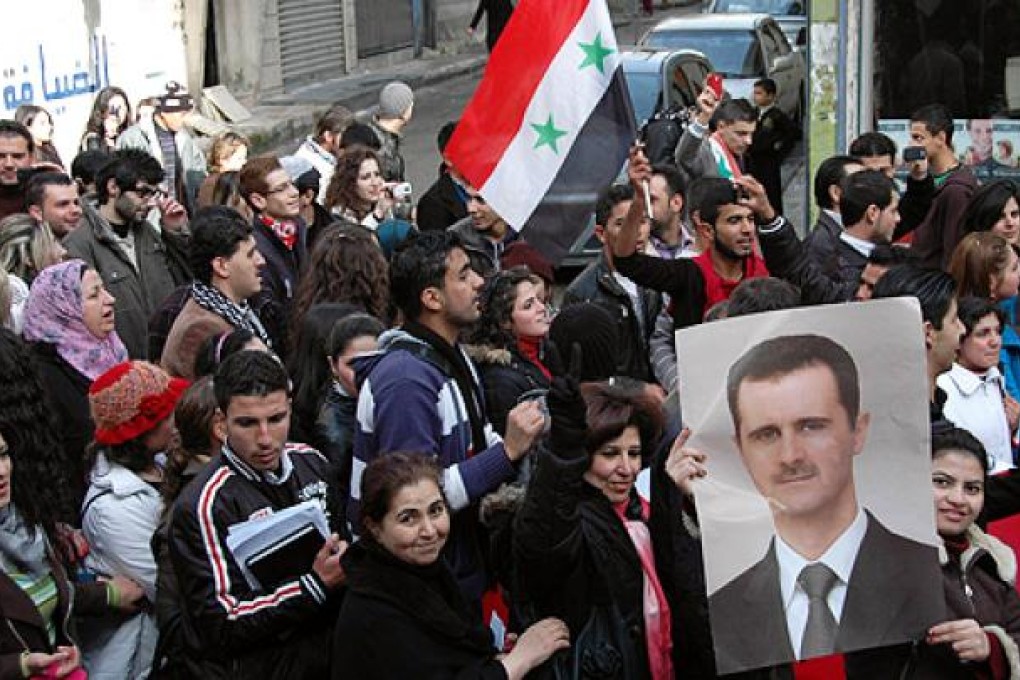 Demonstrators march in support of President Bashar al-Assad in Homs, Syria, on Sunday. Photo: AFP