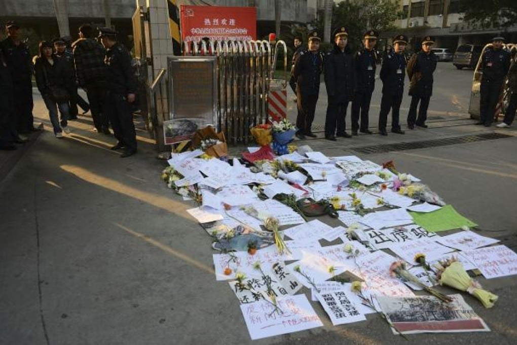 Protest banners and flowers laid outside the headquarters of the Southern Weekly newspaper in Guangzhou on Monday. Photo: AP
