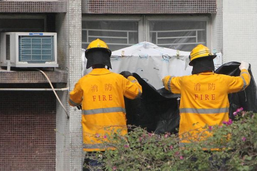 Firefighters cover windows of the woman's flat. Photo: SCMP
