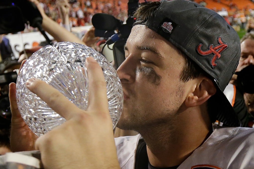 Alabama's star quarterback A.J. McCarron kisses the Coaches' Trophy after beating Notre Dame in the national college football title game in Miami. Photo: AP