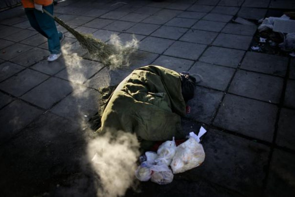 A homeless man sleeps on a Beijing street in the middle of the winter. Photo: AP