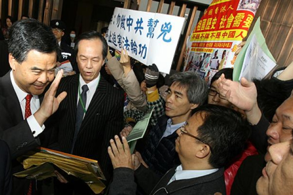 Activists and petitioners greet Chief Executive CY Leung as he enters Central Government Offices in Tamar ahead of an Exco meeting. Photo: Edward Wong