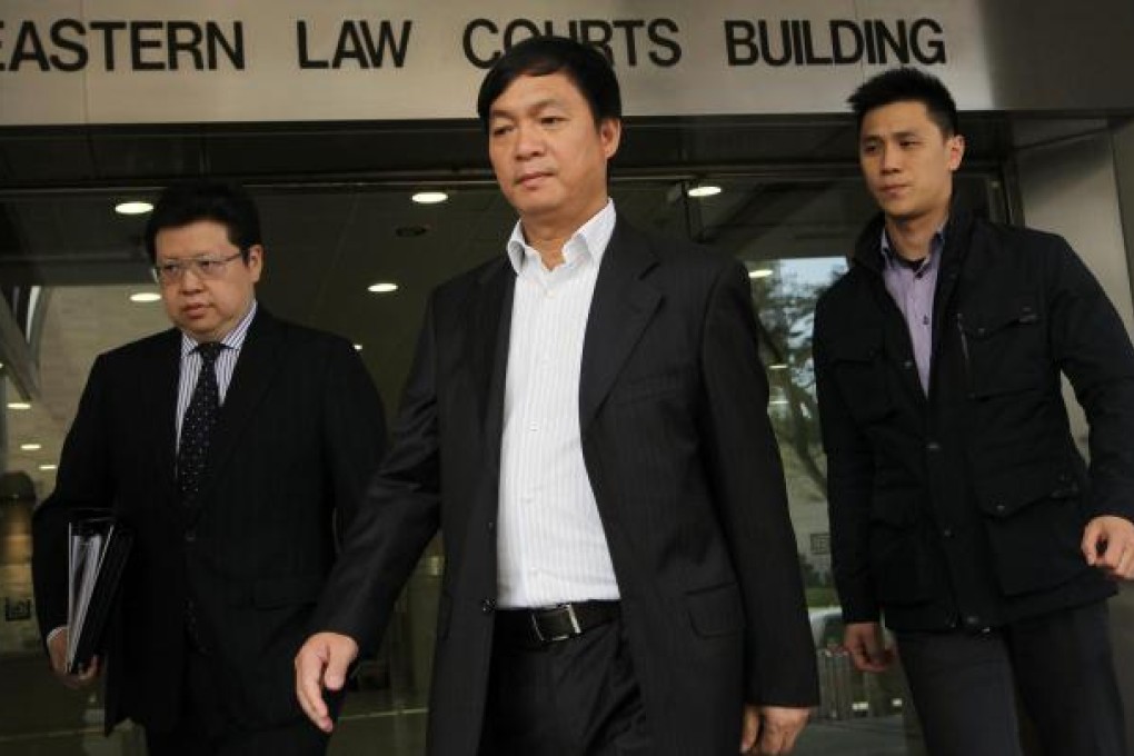 Accompanied by aides, Agile chairman Chen Zhoulin leaves Eastern Court, where he has been charged with attacking a female employee. Photo: Edward Wong