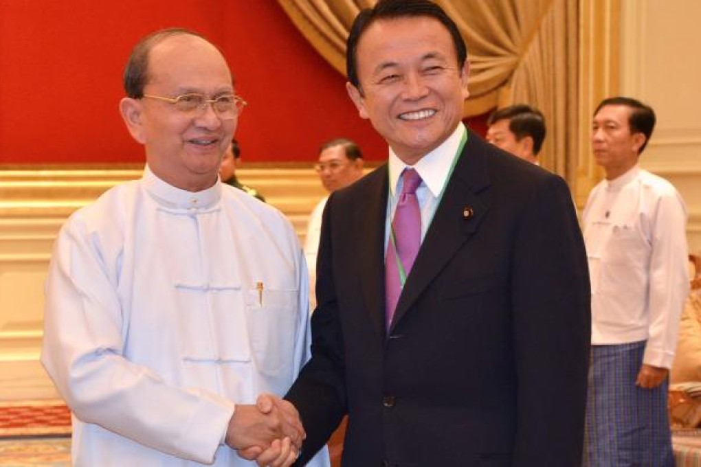 Myanmar President Thein Sein, left, shakes hands with Japanese Finance Minister and Deputy Prime Minister Taro Aso during their meeting at Presidential House in Naypyitaw, Myanmar. Photo: AFP