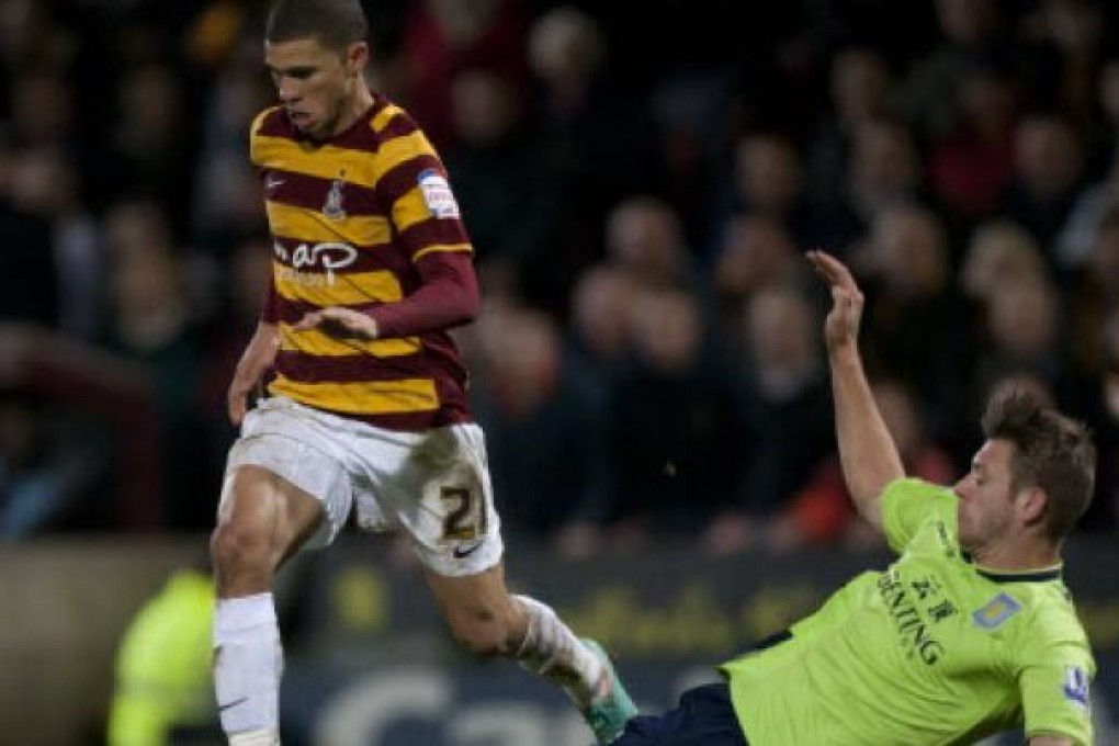 Bradford City's Nahki Wells, left, keeps the ball from Aston Villa's Nathan Baker during their English League Cup semifinal soccer match at Valley Parade Stadium, Bradford, England, on Tuesday. Photo: AP