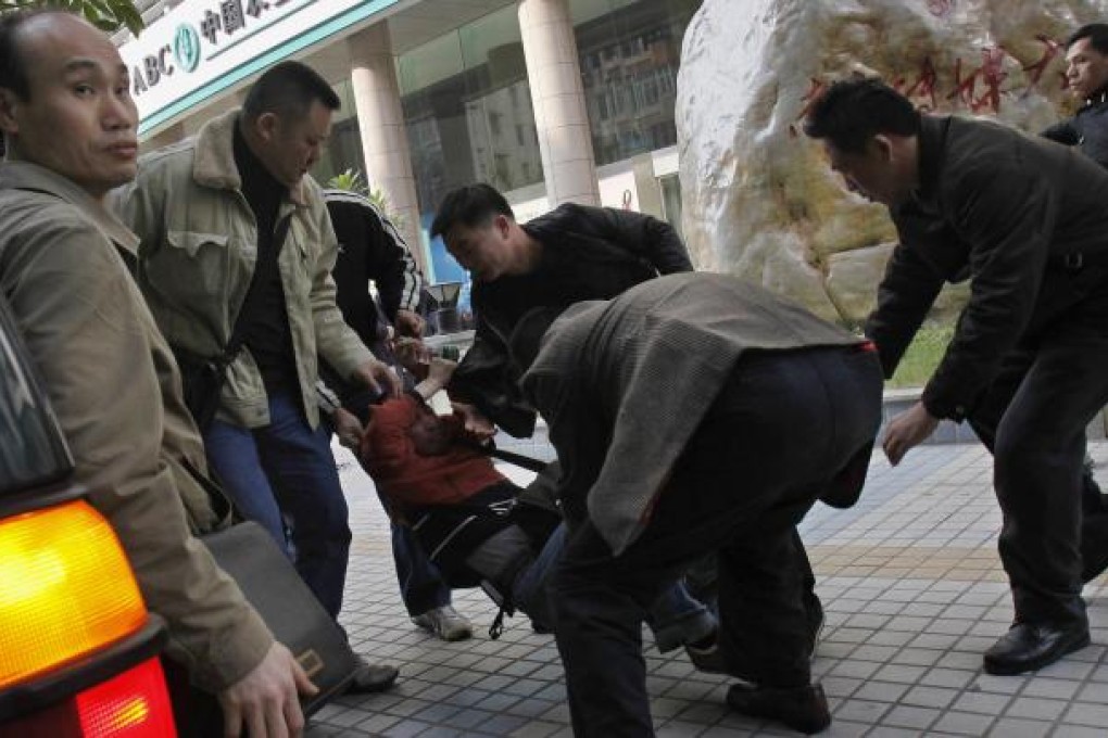 Plainclothes police take away a protester from near the office of Southern Weekly. Photo: Reuters