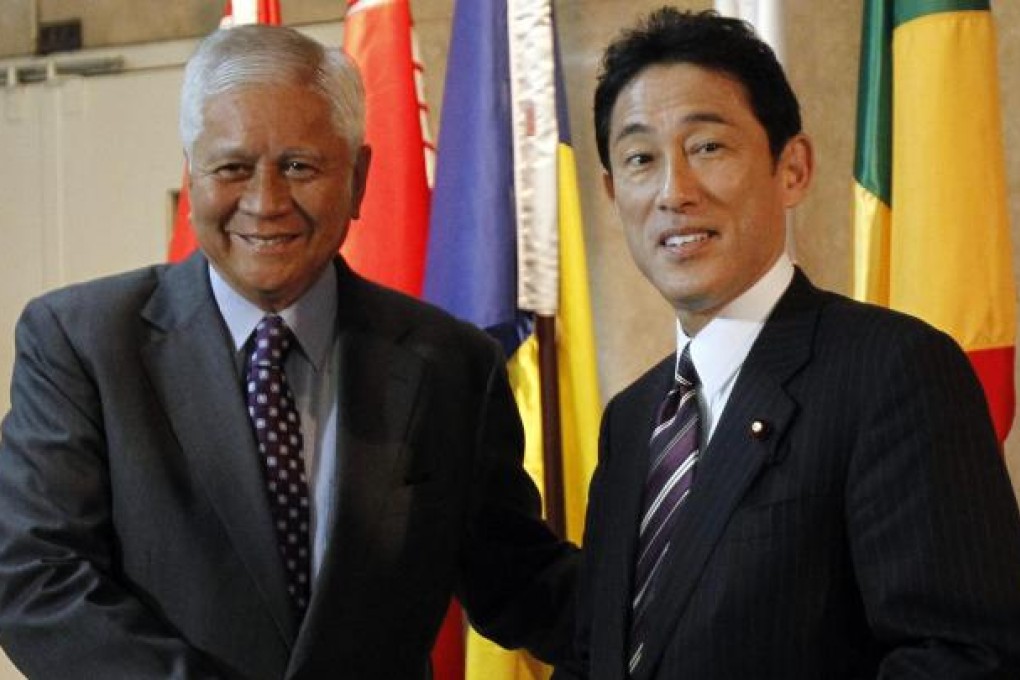 Philippine Foreign Affairs Secretary Albert del Rosario greets Japanese Foreign Minister Fumio Kishida (right) upon his arrival at the Foreign Affairs headquarters in Manila. Photo: Reuters