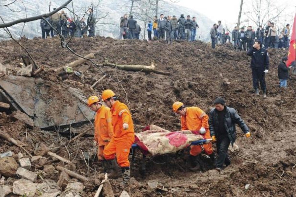 The body of a landslide victim is stretchered away by rescuers in Zhenxiong county. Photo: Reuters