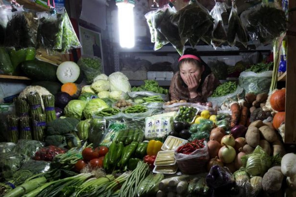 A vegetable vendor waits for customers at a market in Beijing as vegetable prices soar amid bad weather and poor transport. Photo: AP