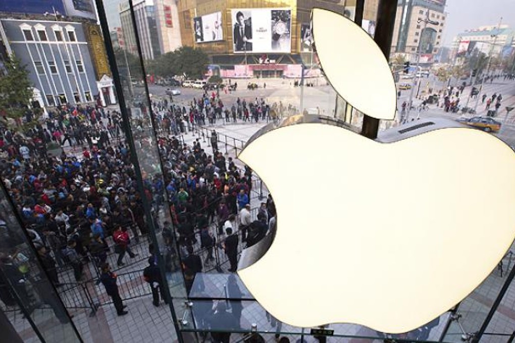 People line up to enter an Apple Store in Wangfujing shopping district in Beijing. Photo: AP