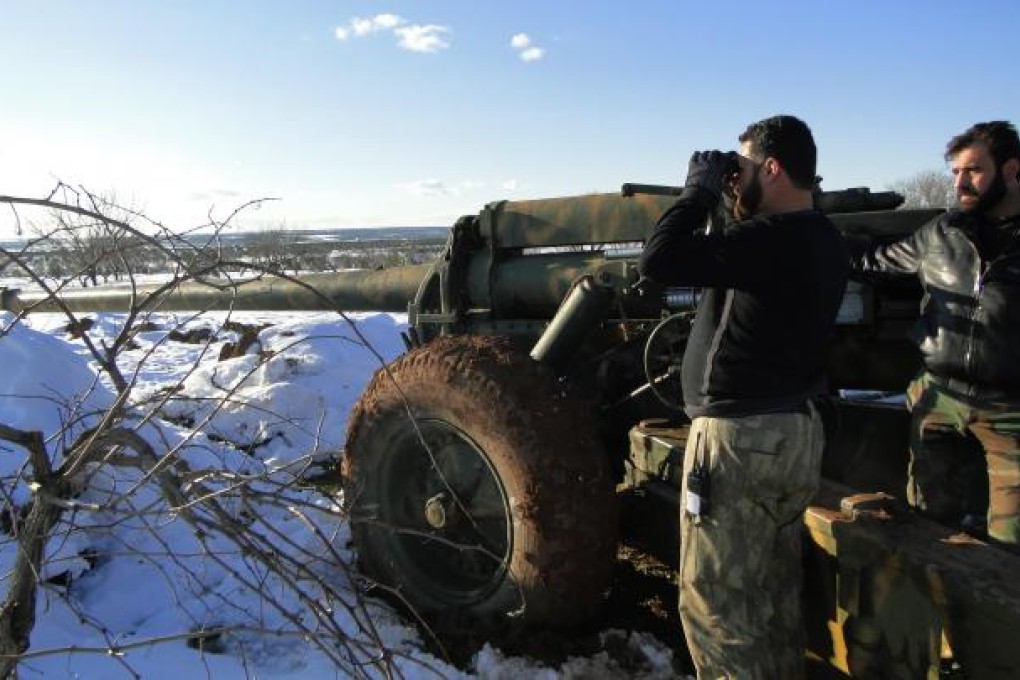 A Free Syrian Army fighter uses binoculars near the Menagh military airport, in Aleppo's countryside. Photo: Reuters