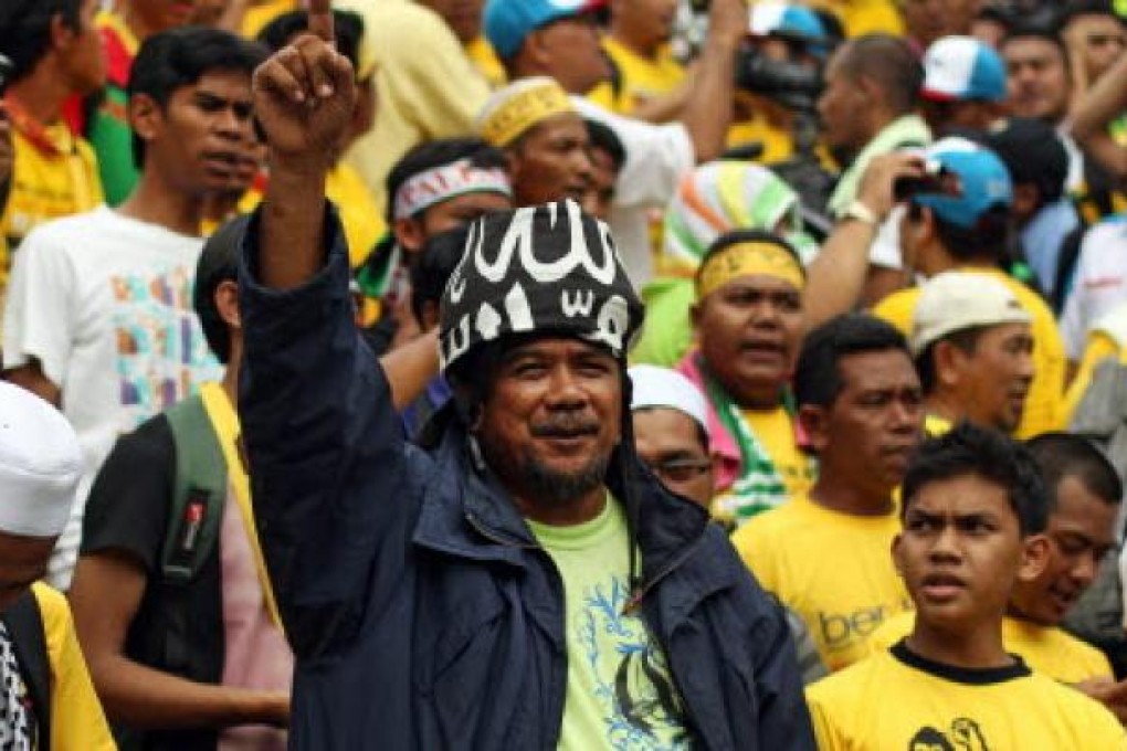 A protester shouts slogans outside the national mosque as they take part in an opposition rally ahead of elections in Kuala Lumpur on Saturday. Photo: AFP