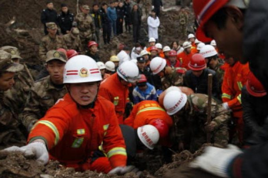 Rescuers work at the mud-inundated debris after a landslide hit Zhaojiagou in Yunnan. Photo: AP