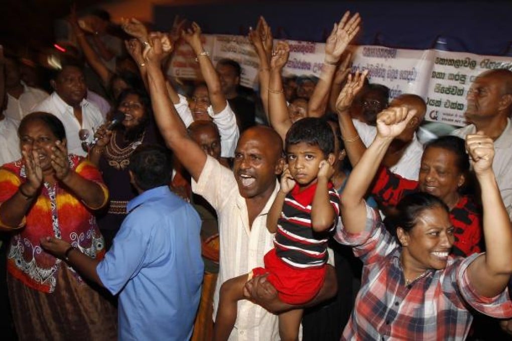 Supporters of Sri Lanka's president Rajapakse celebrate after parliament voted to impeach the country's chief justice Bandaranayake in front of her official residence. Photo: Reuters