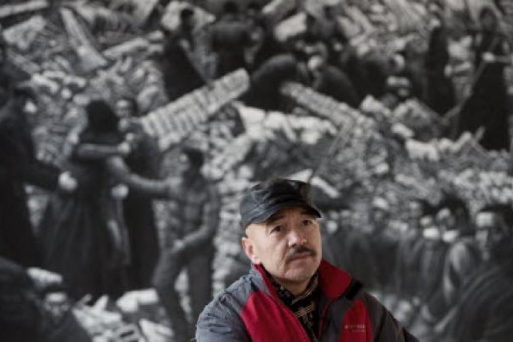 Beijing-based artist Liu Yi pauses in front of his painting of Tibetans at his studio in Songzhuang art village in Tongzhou, on the outskirt of Beijing. Photo: AP