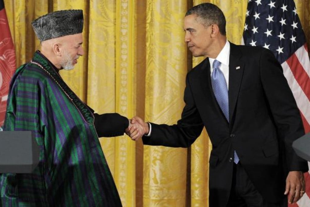 Hamid Karzai and Barack Obama shake hands after putting on a united front at their press conference at the White House. Photo: AFP