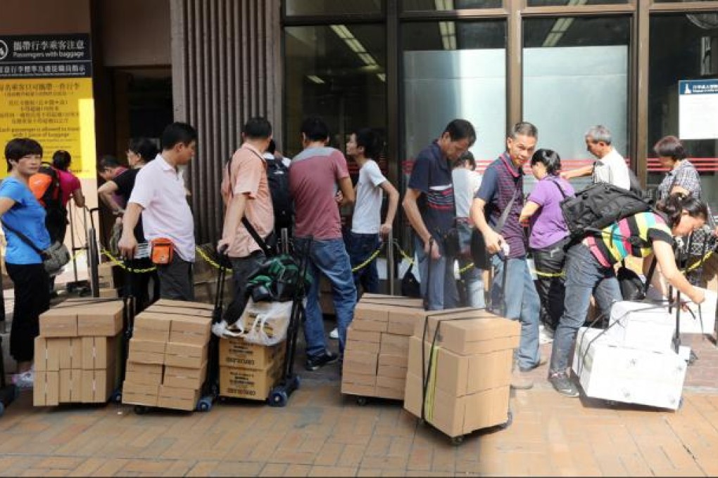 Parallel traders are seen outside Sheung Shui MTR station with their goods. Photo: David Wong