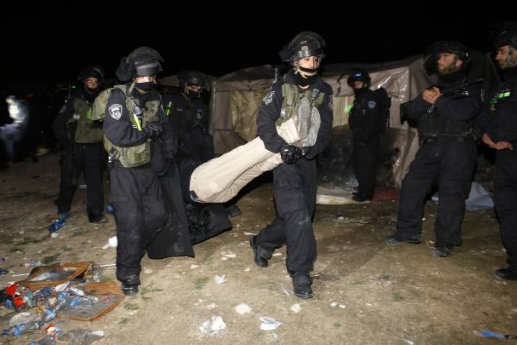 Israeli border police remove a Palestinian from an outpost of tents in an area known as E-1, near Jerusalem. Photo: Reuters