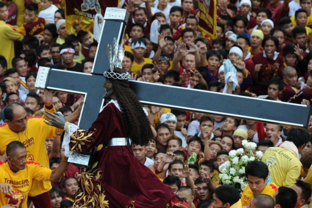 Catholic devotees with a statue of Jesus in Manila. Photo: AFP