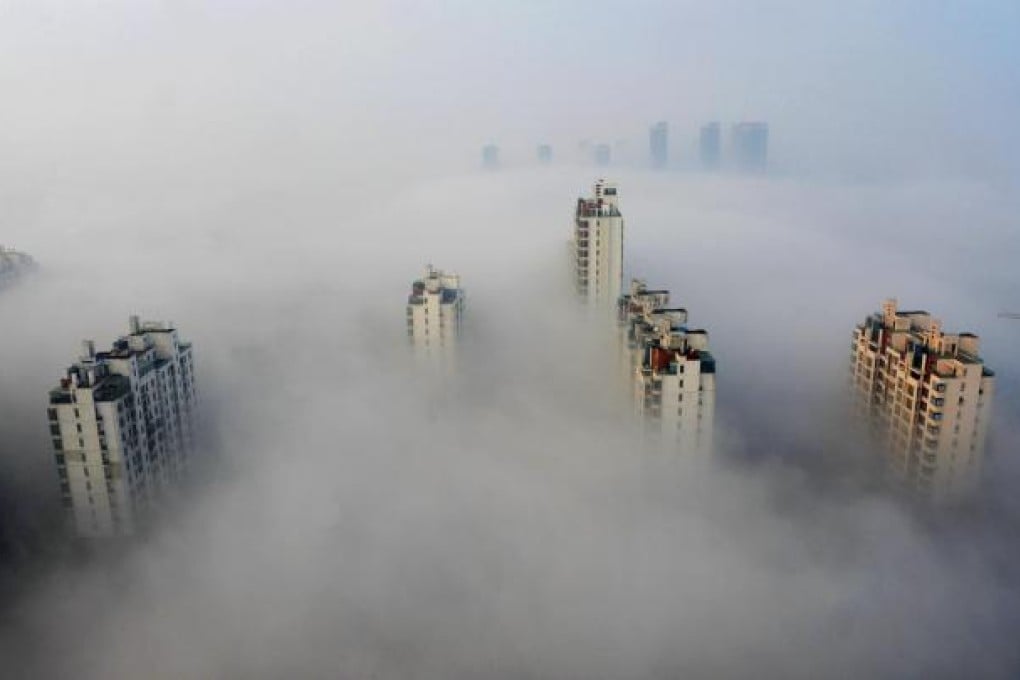 Skyscrapers peek above thick fog in Suzhou yesterday.