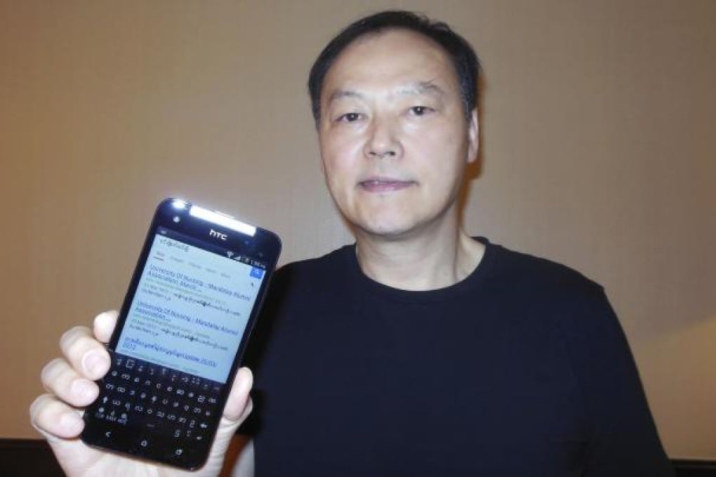 HTC CEO Peter Chou holds one of his devices sporting a new Myanmar font ahead of Monday's launch of the product in Yangon. Photo: Reuters