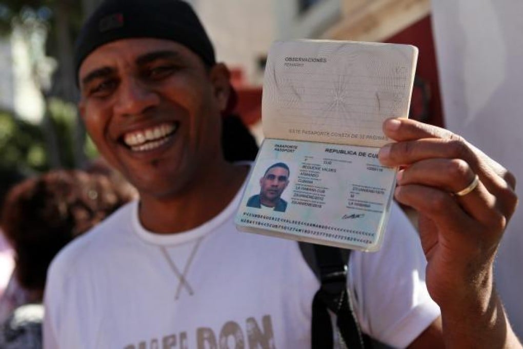 One happy man shows his passport as he leaves immigration offices in Havana, on Monday, the day when the awaited immigration reform became effective in the island. Photo: EPA