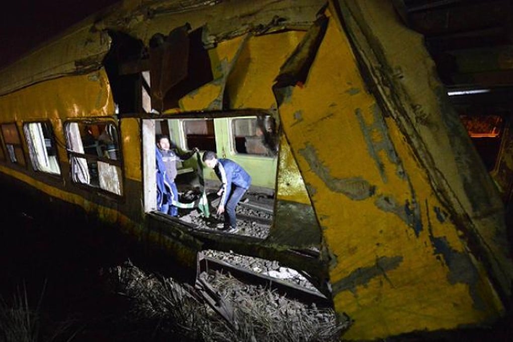 Workers inspect the wreckage of a derailed train 40km south of Cairo. Photo: AFP