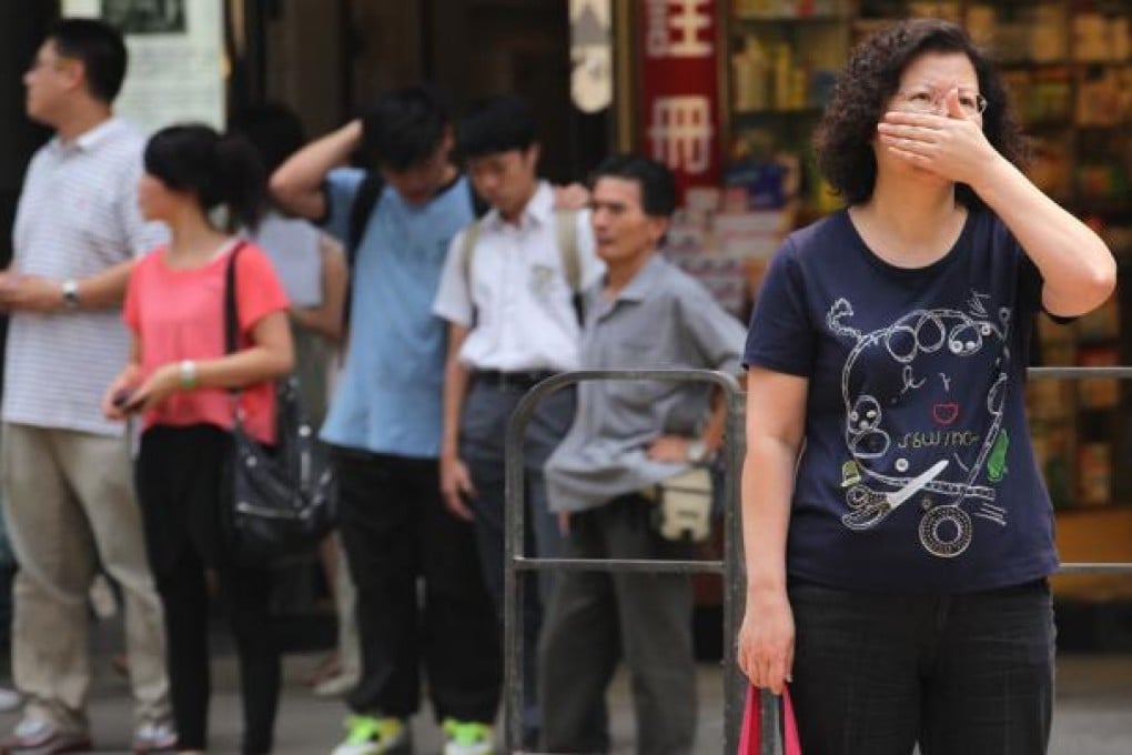 People cover their noses on a street in Mong Kok as the air pollution index of the roadside air monitoring station reached 175. Photo: Nora Tam