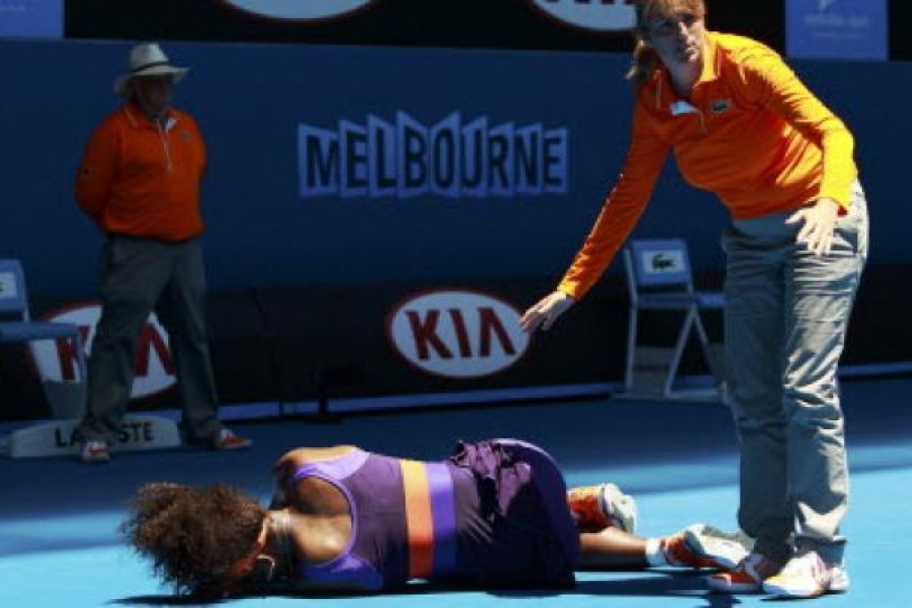 An offical stands over Serena Williams after she fell over during the women's singles match at the Australian Open tennis tournament in Melbourne on Tuesday. Photo: Reuters