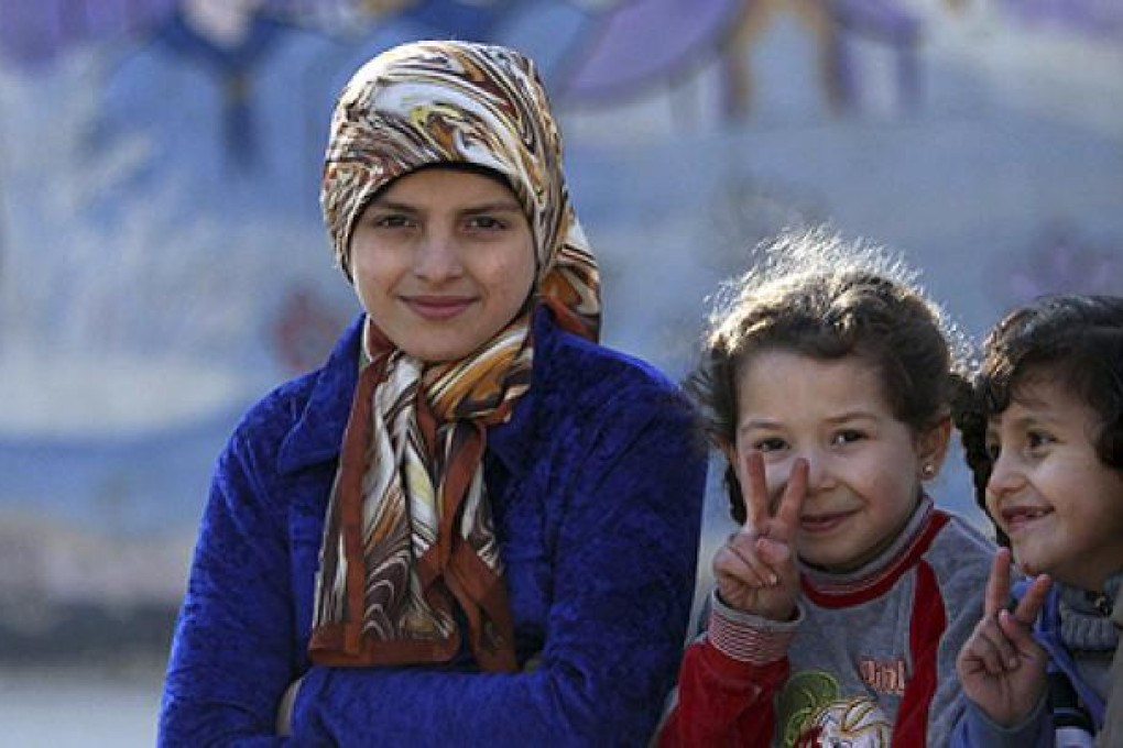 Internally displaced Syrian children gesture as they pose for a photo at a school in Aleppo. Photo: Reuters