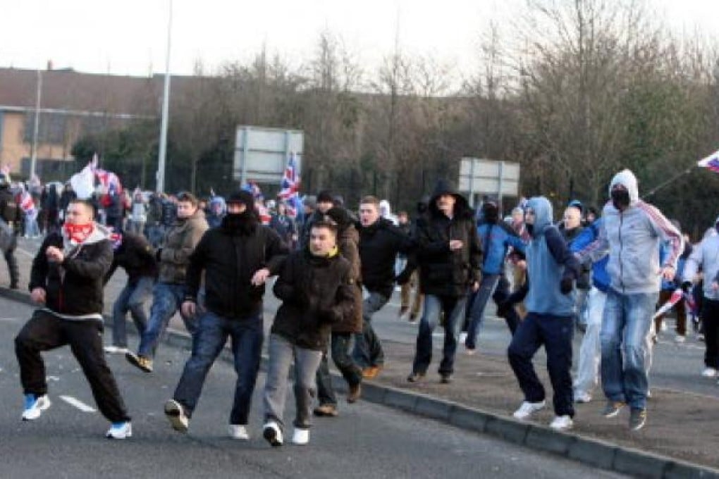 Loyalists react after being attacked by Nationalists throwing stones from the Nationalist Short Strand area of Belfast in Northern Ireland. Photo: EPA