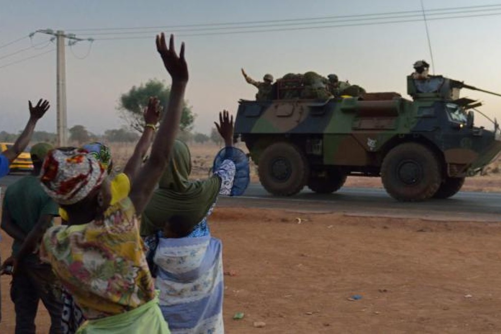 Malian civilians wave as a convoy of French soldiers leaves the capital, Bamako, to battle Islamists in the north. France is providing both air and ground forces. Photo: AFP