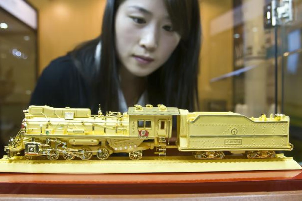 Solid gold bling. A visitor looks at a gold model locomotive at a luxury exhibition in Beijing, capital. A new survey has found that the top one per cent of Chinese families make an average 1.51 million yuan a year. Photo: Xinhua
