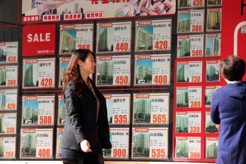 This photo taken on December 4, 2012 shows people in front of a real estate office in Shanghai. Photo: AFP