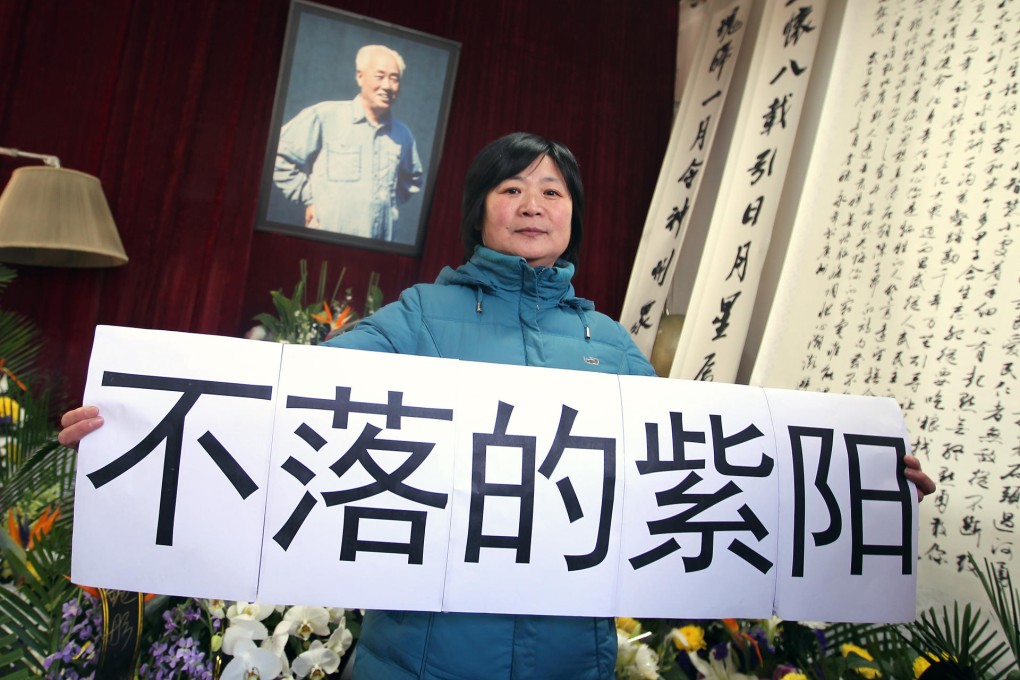 Liu Yong, from Tianjin, at Zhao’s home on the anniversary of his death yesterday with a poster saying “Ziyang [literally ‘purple sun’] will never set”. Photo: Simon Song