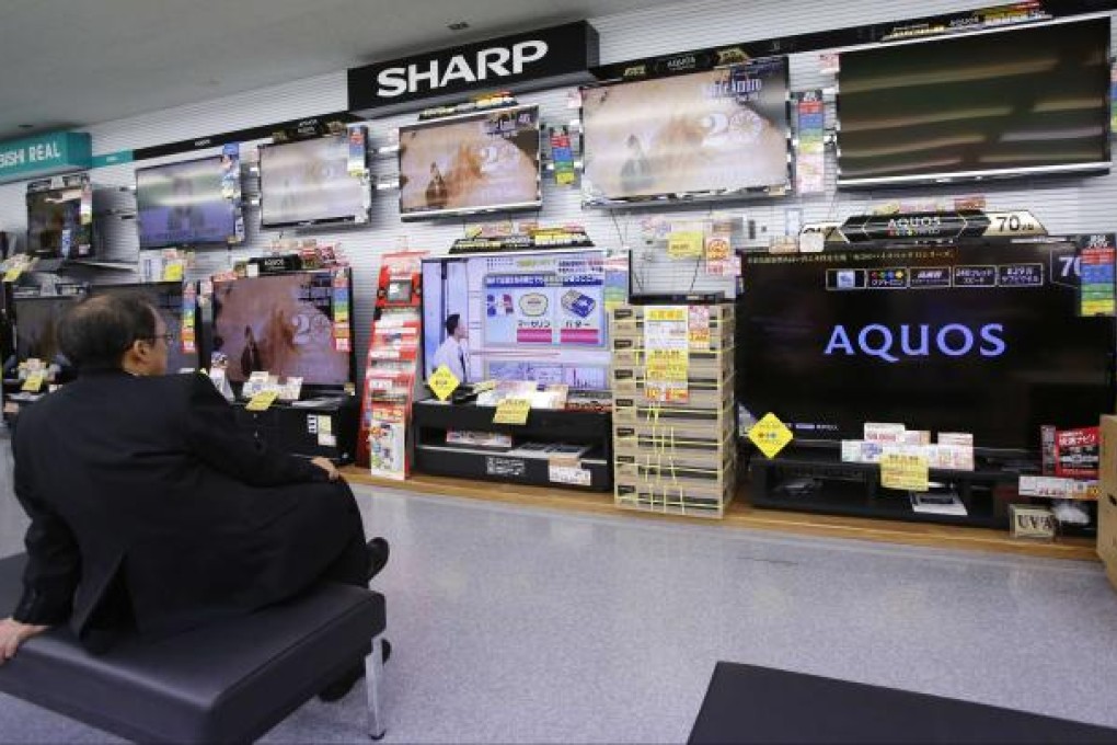 A shopper looks at Sharp LCD screens in a Tokyo shop. Sharp is in talks with Lenovo about selling an LCD TV plant in Nanking and tying up with the Chinese computer company. Photo: Reuters