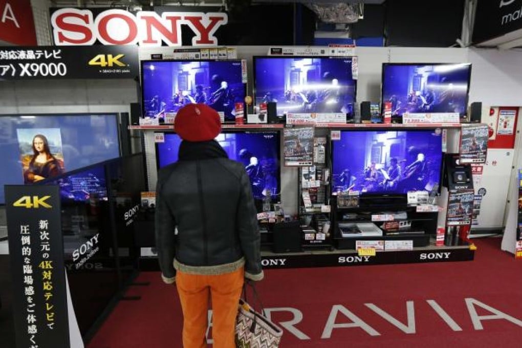 A shopper checks out Sony products at a Tokyo outlet. The company has been mauled by tough competition from South Korean competitors, particularly Samsung Electronics, and is selling assets to raise cash. Photo: Reuters