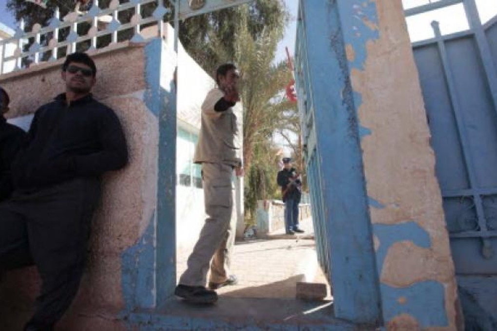 An Algerian guard gestures at the main entrance of a hospital in In Amenas, as people wait to know the fate of their relatives who were taken hostage by Islamist militants in a gas facility. Photo: Reuters