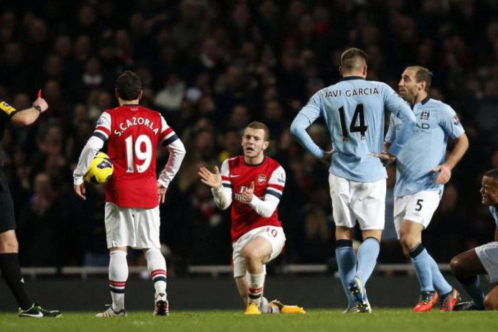 Manchester City captain Vincent Kompany (1st right) was shown a red card for a tackle on Jack Wilshere (3rd left) of Arsenal. Photo: Xinhua