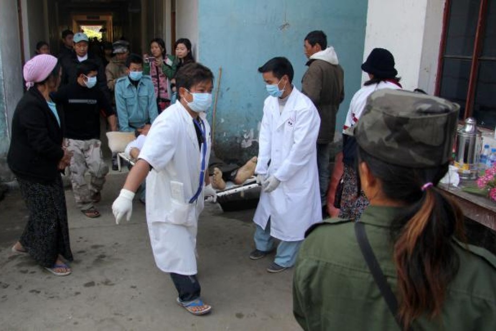 Medical staff carry a man on a stretcher in Laiza. Photo: AFP