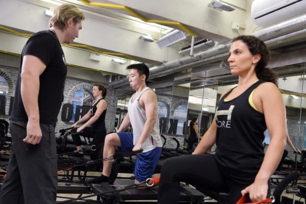 Sebastien Lagree puts reporter Ben Sin through the workout the Frenchman developed at H-Kore, in Central. Photo: Warton Li