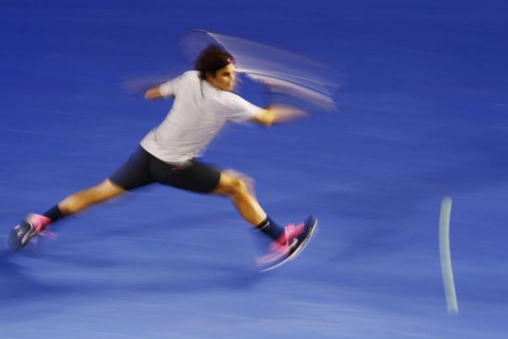 Roger Federer hits a return to Milos Raonic. Photo: Reuters