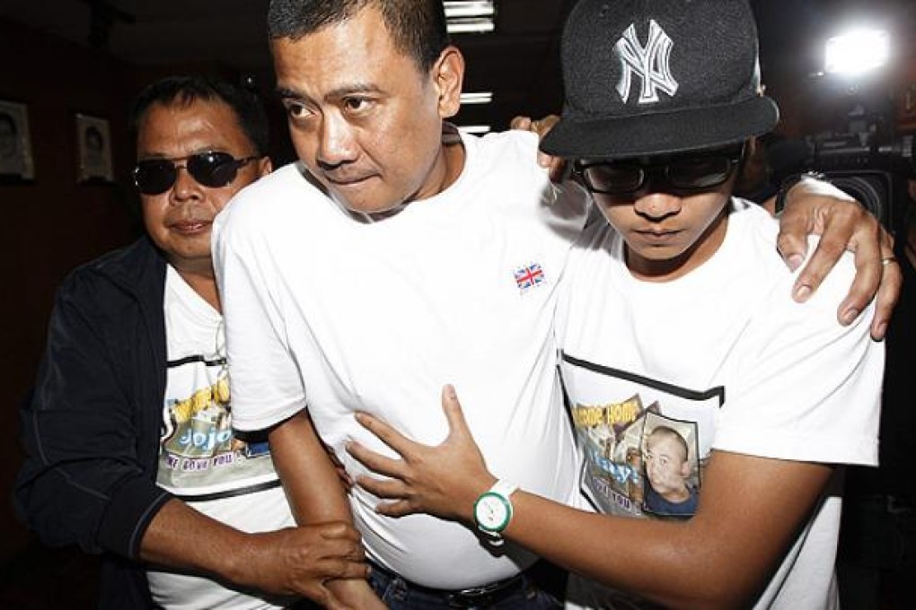 Joseph Balmaceda, centre, is helped to a vehicle in Manila. Photo: AP