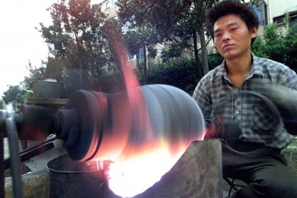 A street vendor swivels a traditional Chinese kernel popper on a Shanghai street. Photo: AFP