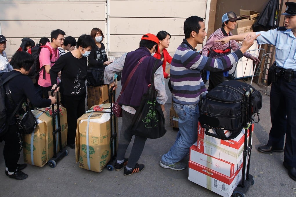 Suspected parallel traders queue outside Sheung Shui MTR station yesterday. A shortage of infant milk formula has hit the city. Photo: Sam Tsang