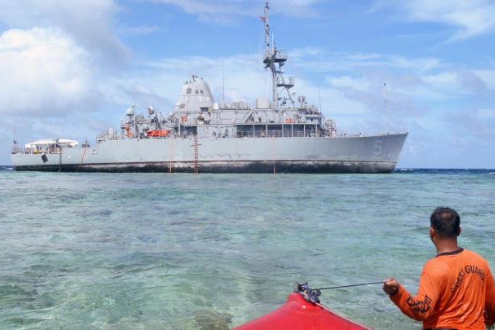 A Philippine coastguard officer wades towards the grounded US minesweeper Guardian. Photo: AFP